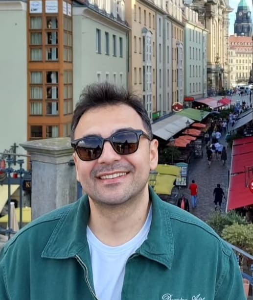 Portrait of Yunus Emre Keskin smiling, wearing sunglasses in Dresden's old town